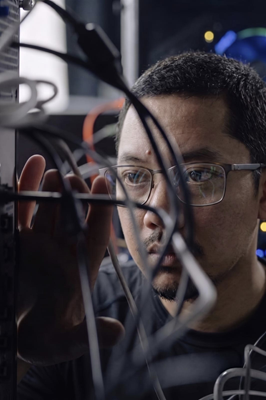 Adam Wirawan working with server cables